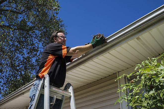 a technician repairing a gutter system in Hales Corners